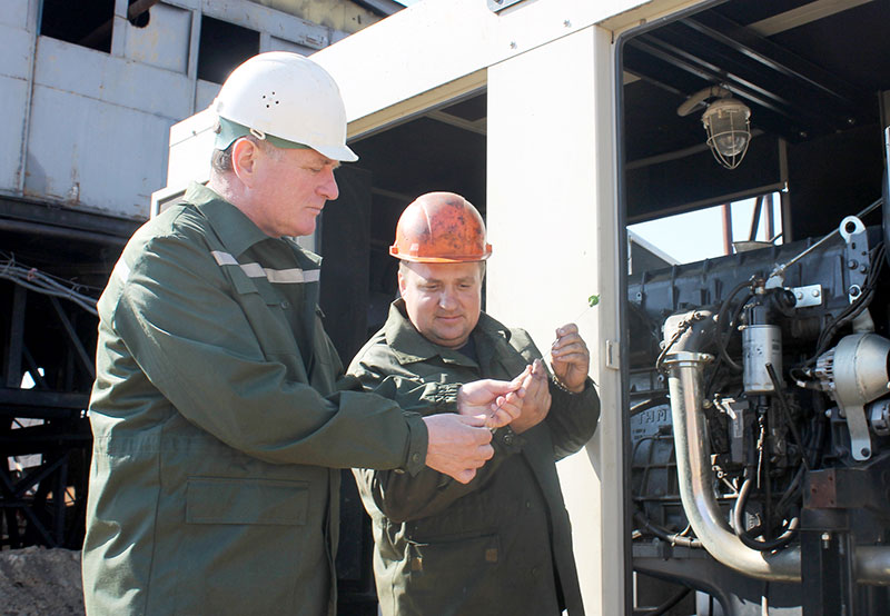 Главный механик А .Т. Свириденко и машинист буровых установок на нефть и газ В. А. Туровец проводят техобслуживание электростанции.